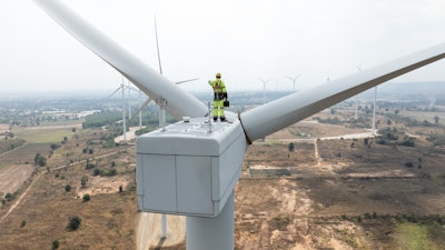 Engineer standing on wind turbine.
