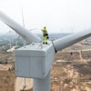 Engineer standing on wind turbine.