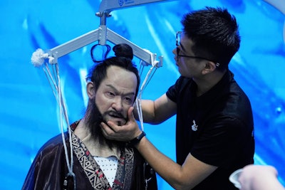 A man adjusts a humanoid robot at the Robot Mall, said to be the world's first humanoid intelligent robot 4S store, in Beijing, China, Wednesday, Aug. 6, 2025.