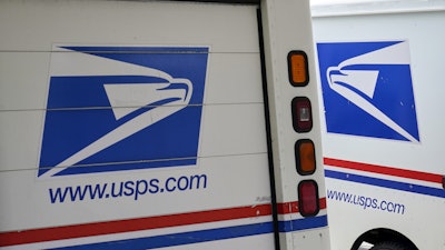 U.S. Postal Service delivery vehicles are parked outside a post office in Boys Town, Neb., Aug. 18, 2020.