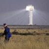 A shepherd watches livestock near Khi Solar One, a solar thermal plant that converts the sun's light energy into electricity, outside Upington, South Africa, in the Northern Cape province, Friday, Aug. 29, 2025.