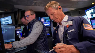 Trader Robert Charmak, right, and specialist Glenn Carell, center, work on the floor of the New York Stock Exchange, Sept. 10, 2025.