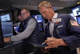 Trader Robert Charmak, right, and specialist Glenn Carell, center, work on the floor of the New York Stock Exchange, Sept. 10, 2025.
