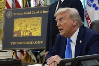 A poster showing the Trump Gold Card is seen as President Donald Trump signs executive orders in the Oval Office of the White House, Friday, Sept. 19, 2025, in Washington.