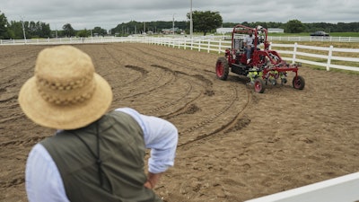 MK Bashar, right, test drives an electric tractor as Ben Phillips, left, watches Tuesday, Aug. 19, 2025, during a demonstration in East Lansing, Mich.