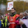 A worker holds a sign reading 'investing instead of saving' during a nationwide warning strike of the union IG Metal at the car maker FORD factory in Cologne, Germany, Germany, Oct. 29, 2024.