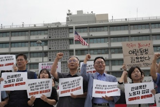 Protesters stage a rally against the detention of South Korean workers during an immigration raid in Georgia, near the U.S. Embassy in Seoul, South Korea, Tuesday, Sept. 9, 2025. The signs read 'A tariff bomb and workers confinement.'