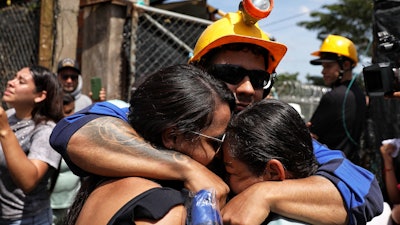 A miner embraces his relatives after he was rescued from a gold mine that had collapsed in Segovia, Colombia, Wednesday, Sept. 24, 2025.