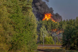 Smoke and flames rise following powerful explosions after several rail cars loaded with liquefied gas caught fire in the suburbs of Vilnius, Lithuania, Wednesday, Sept. 10, 2025.