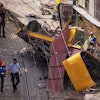 Police officers inspect the site where a tourist streetcar derailed and crashed in Lisbon, Portugal, Thursday, Sept. 4, 2025.