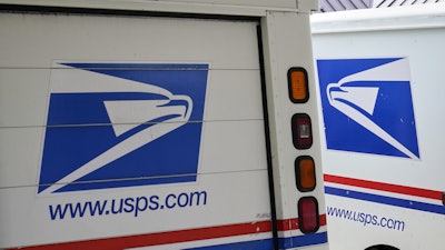 U.S. Postal Service delivery vehicles are parked outside a post office in Boys Town, Neb., Aug. 18, 2020.