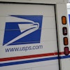 U.S. Postal Service delivery vehicles are parked outside a post office in Boys Town, Neb., Aug. 18, 2020.