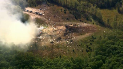 Smoke fills the air as debris covers the ground and vehicles after a powerful blast ripped through a military explosives manufacturing plant in Hickman County, Tenn., on Friday, Oct. 10, 2025.