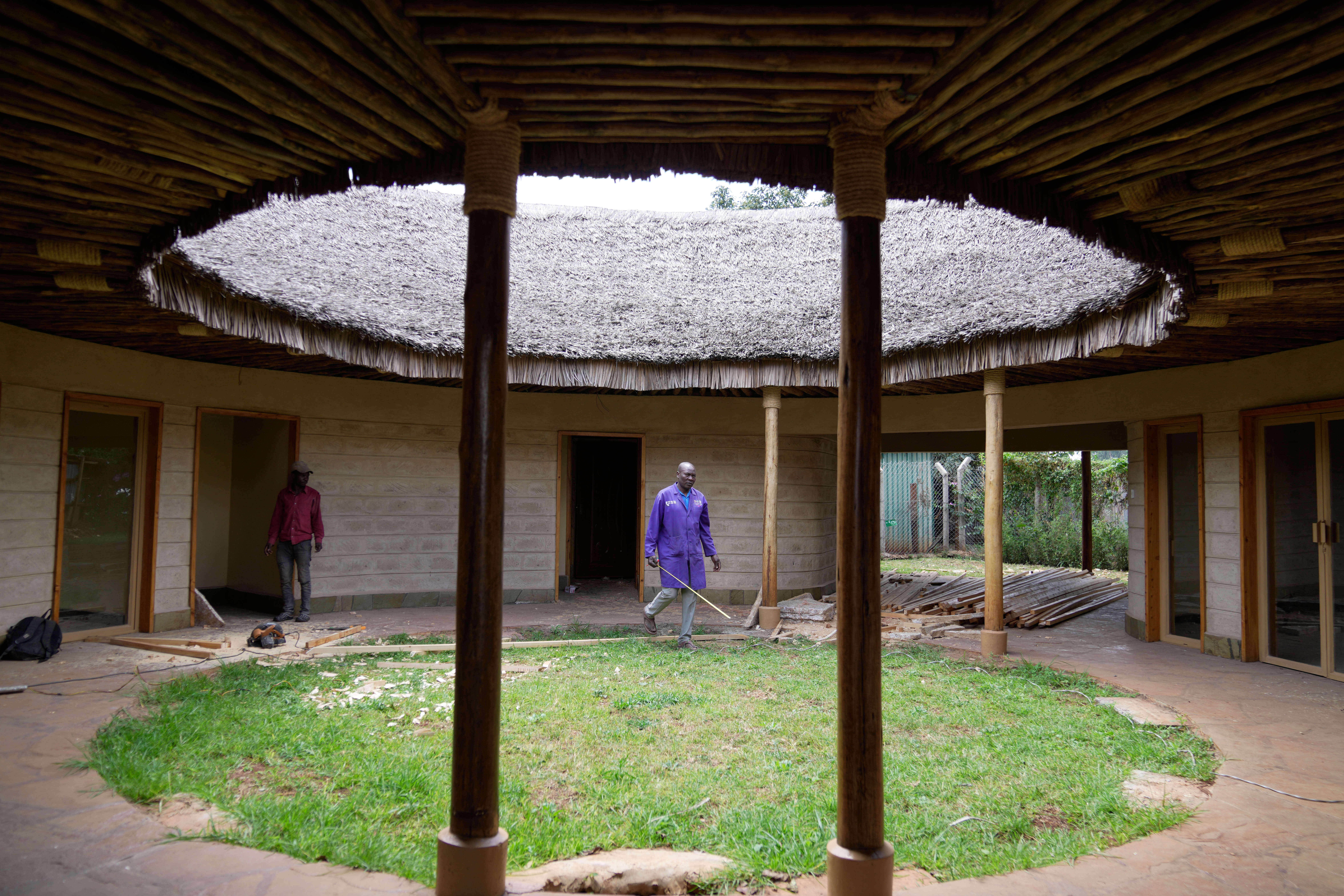 A contractor takes measurements inside a house under construction, inspecting wall and roof insulation made from agricultural waste and mushroom mycelium in Nairobi, Kenya, Friday, Sept. 12, 2025.