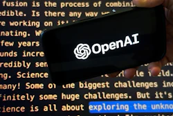 The OpenAI logo appears on a mobile phone in front of a screen showing part of the company website in this photo taken on Nov. 21, 2023 in New York.