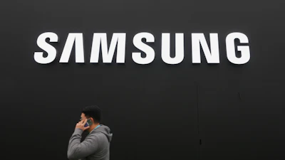 A person walks by a logo of Samsung Electronics at an exhibition hall for the Asia-Pacific Economic Cooperation (APEC) in Gyeongju, South Korea, Thursday, Oct. 30, 2025.