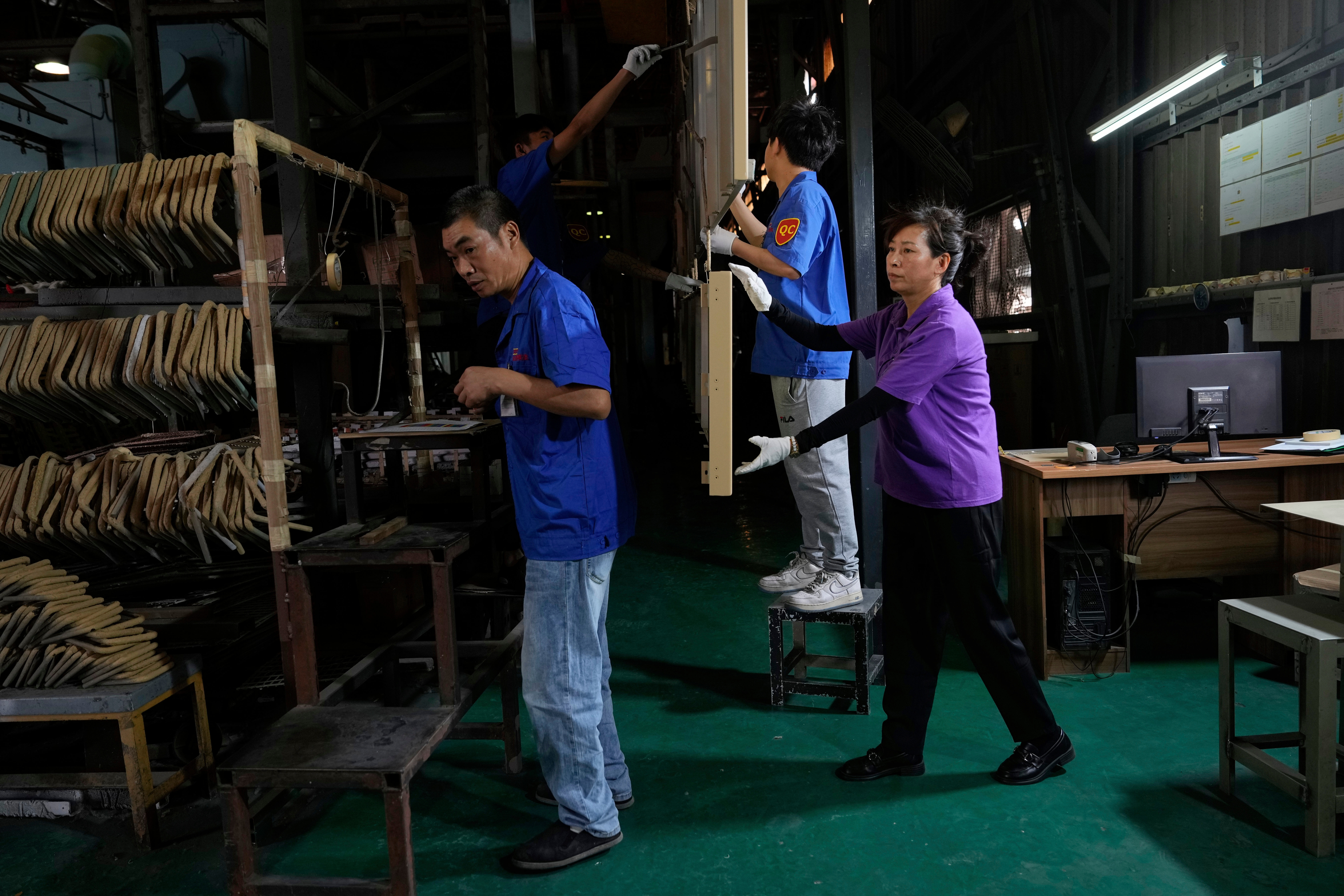 Workers check aluminum panels produced at a factory of Kam Pin Industrial (HK) Ltd, in Dongguan city in southern China's Guangdong province April 17, 2025.