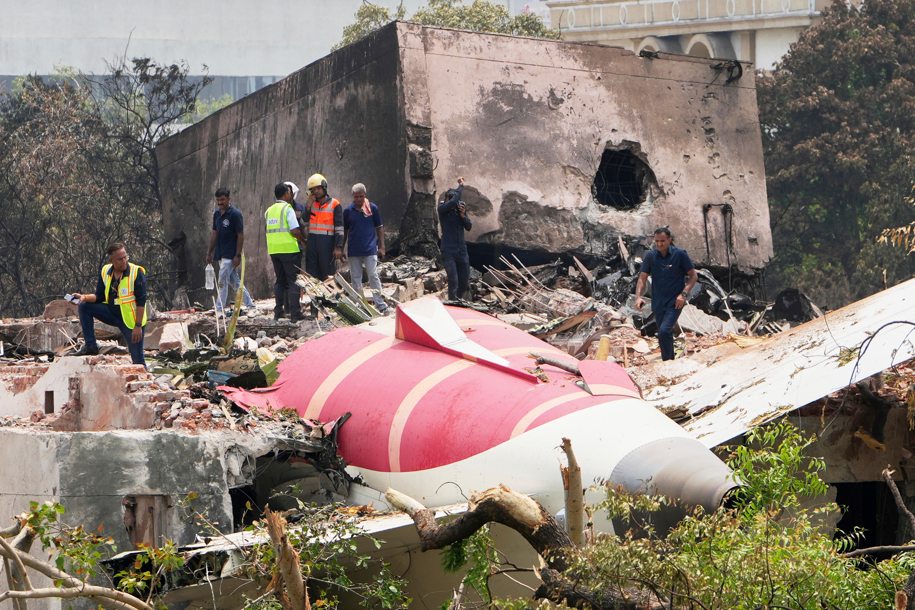 Officials inspect the site of Air India plane crash on the roof of a building in Ahmedabad, India, June 13, 2025.