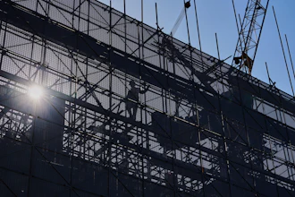 A worker installs scaffolding at a building under construction at the capital popular shopping district, in Beijing, Tuesday, Oct. 21, 2025.