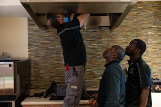 Maintenance workers Enaytullah Hafizi, left, originally from Afghanistan, Eric Frimpong, center, originally from Ghana, and Melvin Palmer, right, originally from Sierra Leone, fix an overhead light at Goodwin House Alexandria, Thursday, Oct. 16, 2025, in Alexandria, Va.