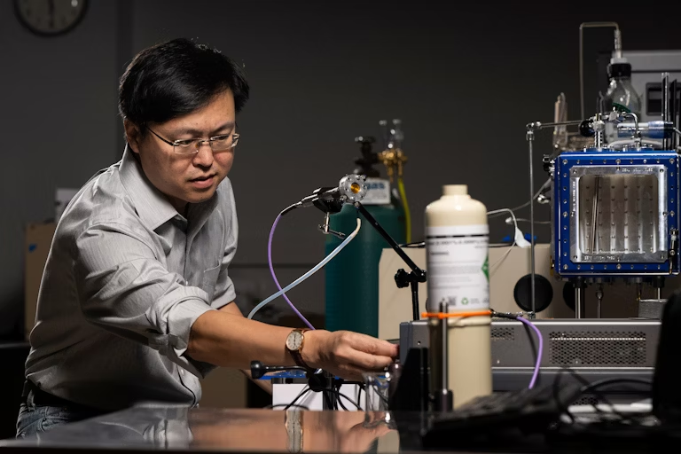 Prof. Jie Huang stands with the MOF-based breathalyzer his lab developed with support from the NIH.