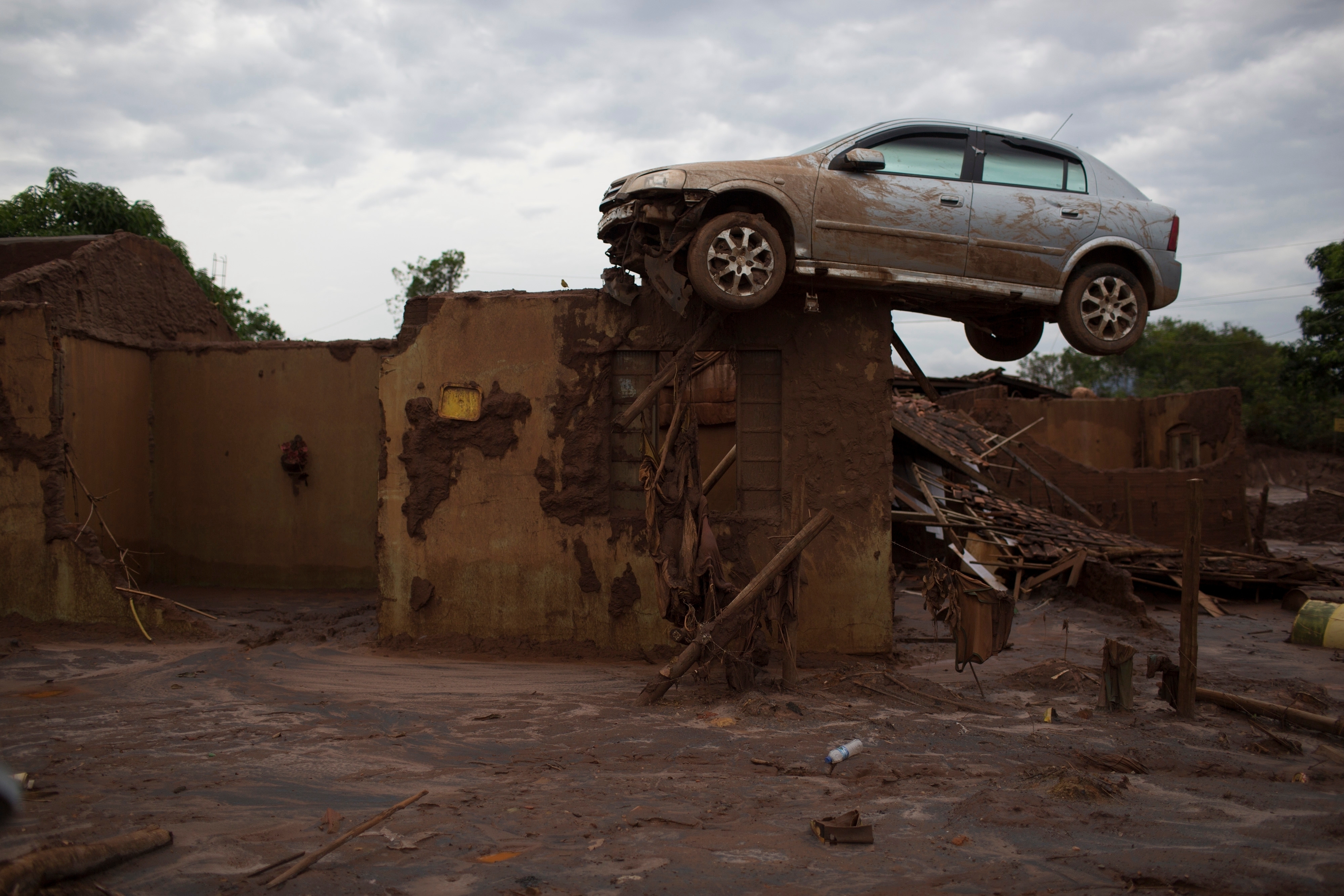 A car sits on top of a wall of a home, destroyed when a dam burst in Bento Rodrigues, Brazil, on Nov. 23, 2015.