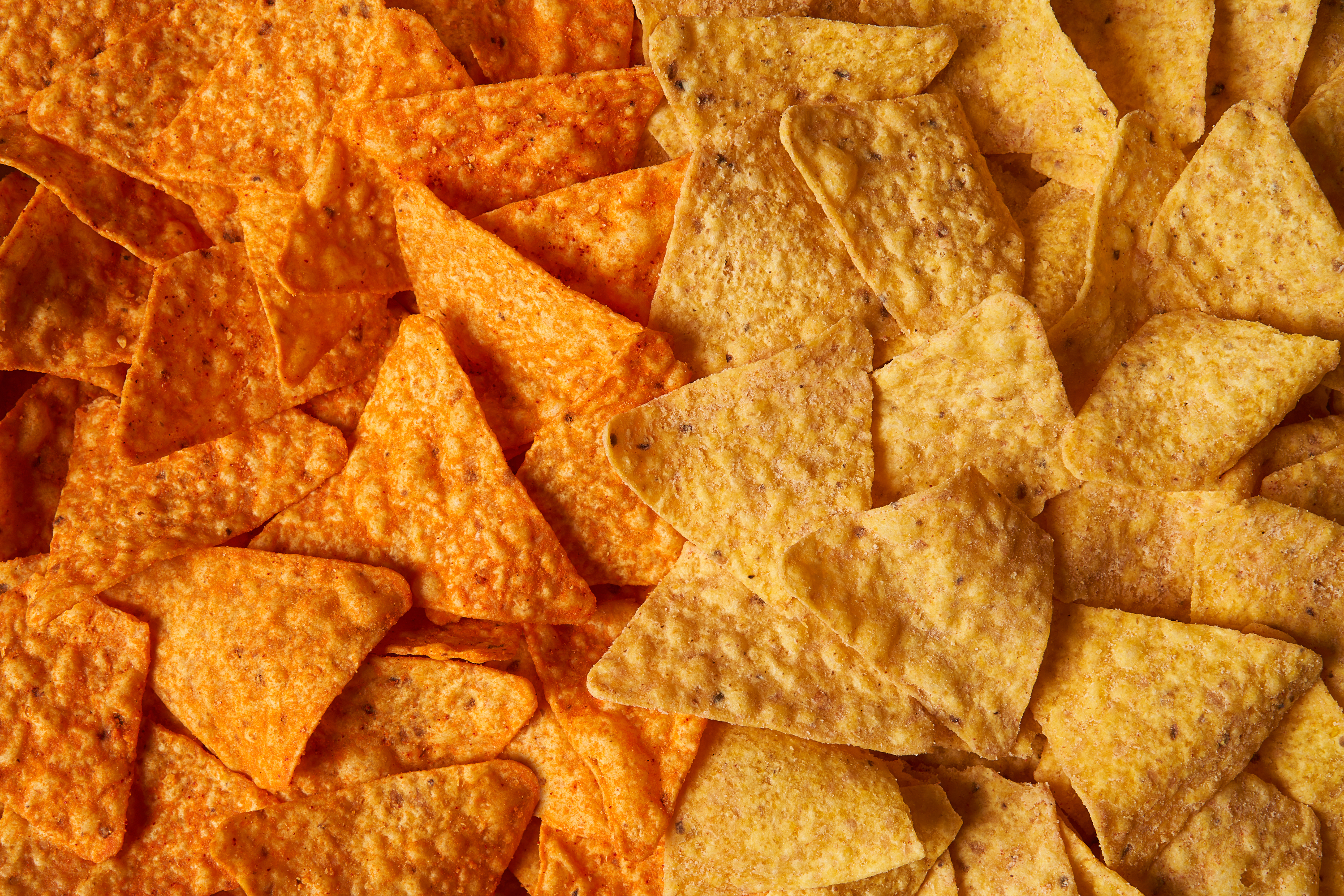 This image provided by PepsiCo shows, from left, original Doritos Nacho cheese chips next to new Doritos without artificial colors or flavors.