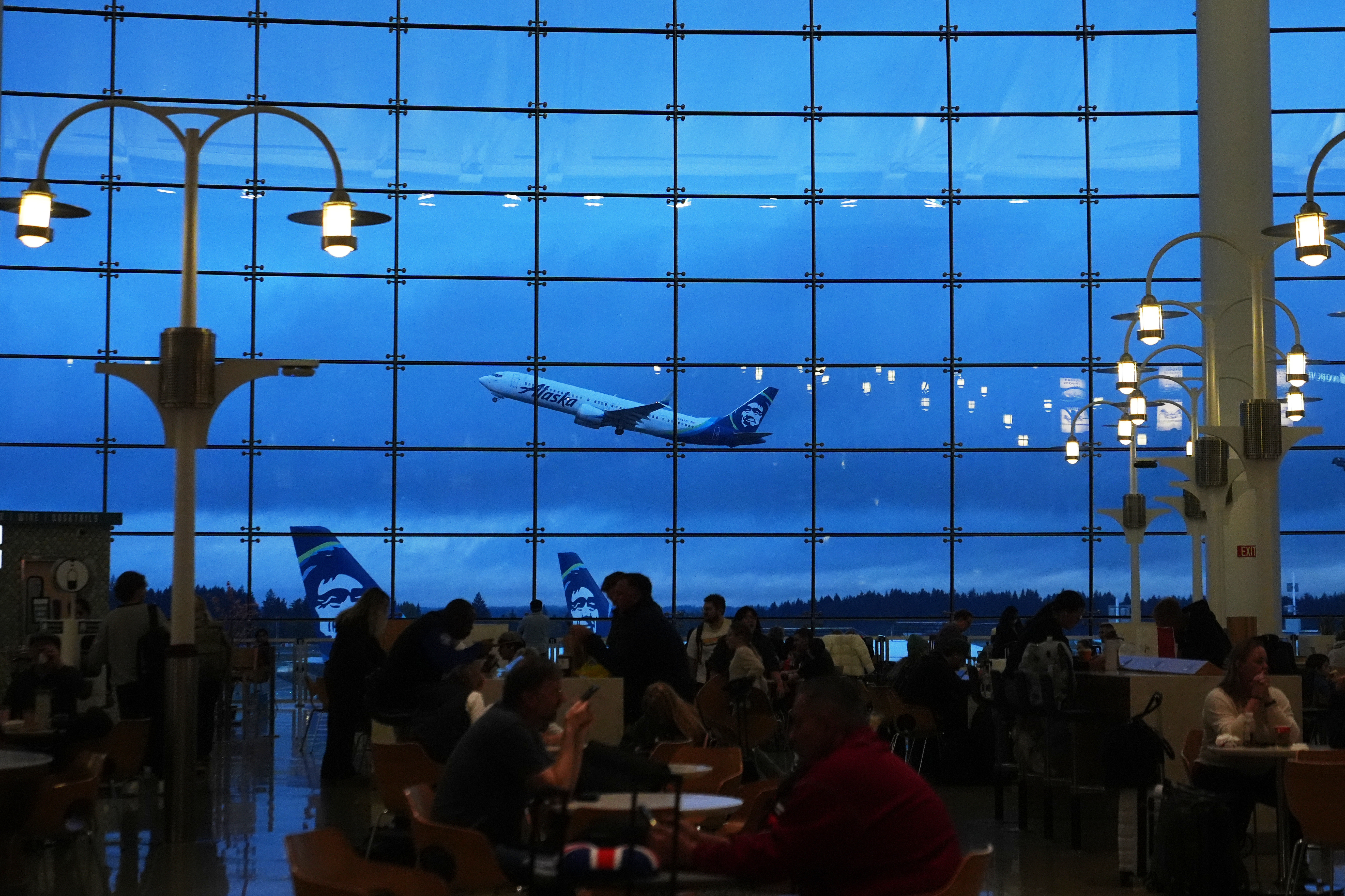 An Alaska Airlines airplane is seen from the central terminal as it takes off at Seattle-Tacoma International Airport Sunday, Nov. 23, 2025, in SeaTac, Wash.