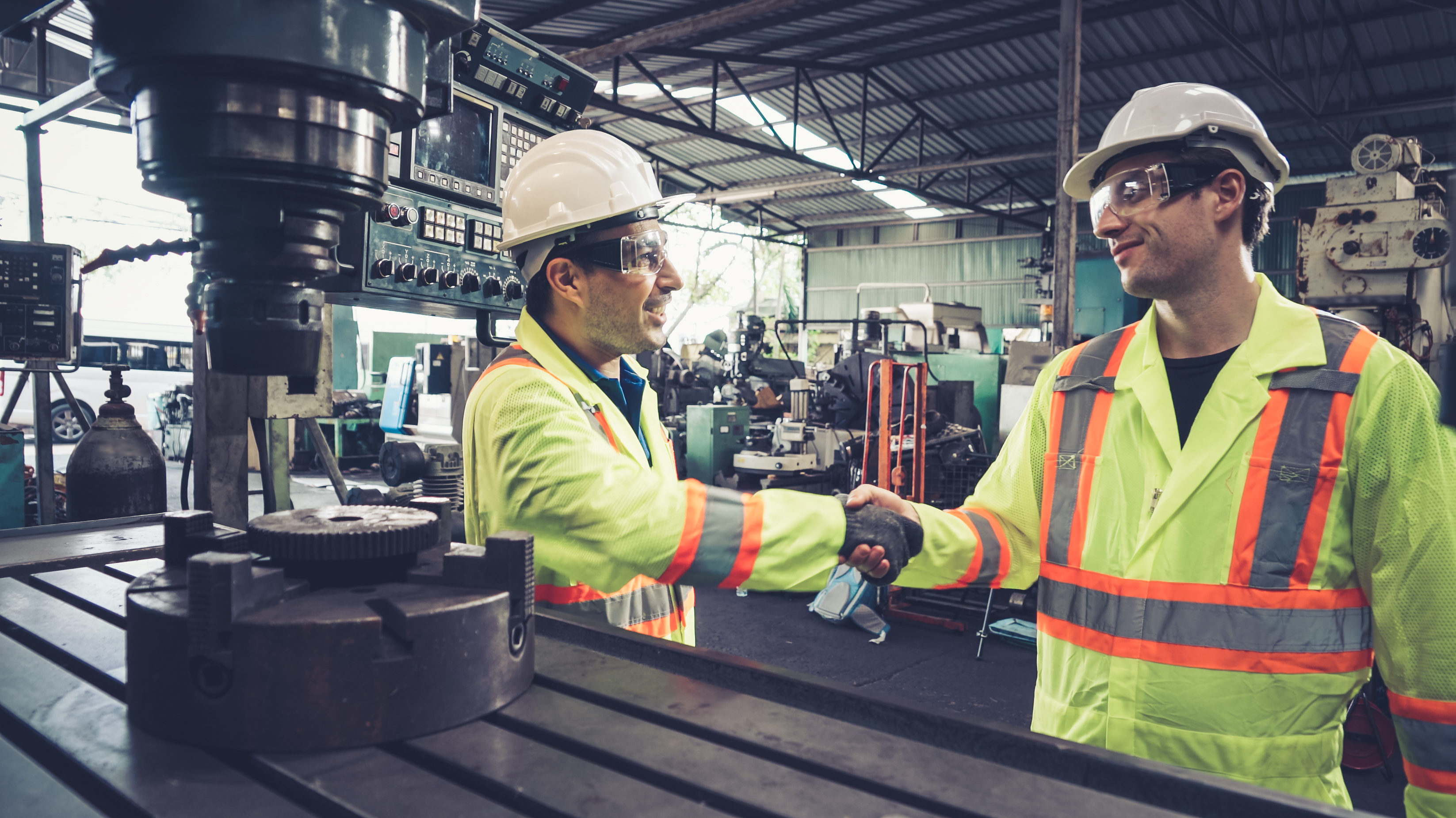 Factory workers shake hands in the factory.