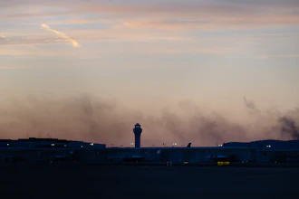 The ATC tower is seen while smoke rises from the crash site of UPS Flight 2976 near Louisville Muhammad Ali International Airport on Wednesday, Nov. 5, 2025, in Louisville, Ky.