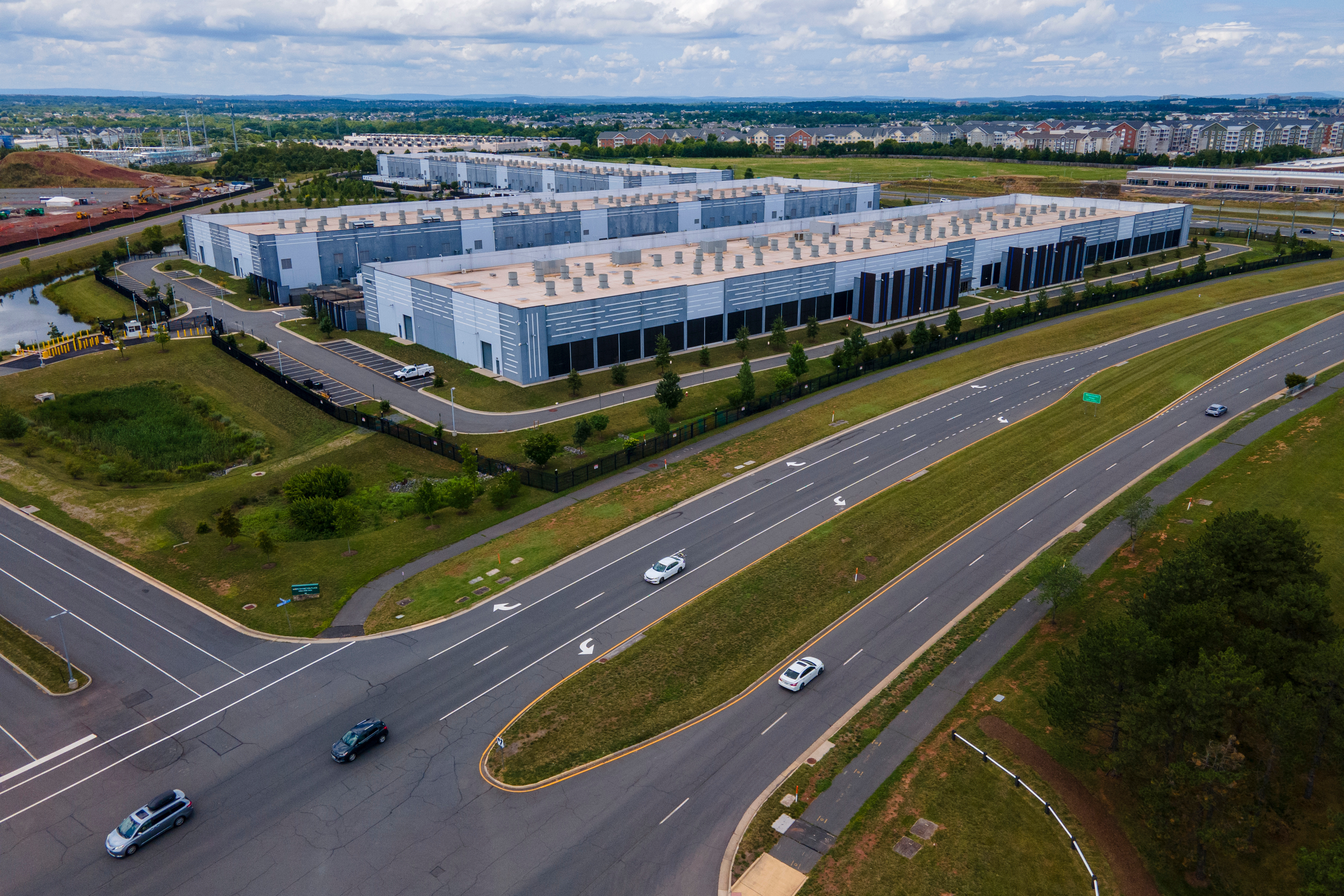 Cars drive past data centers that house computer servers and hardware required to support modern internet use, such as artificial intelligence, in Ashburn, Virginia, July 16, 2023.