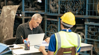 Manufacturer reviewing documents amid the recruitment process.