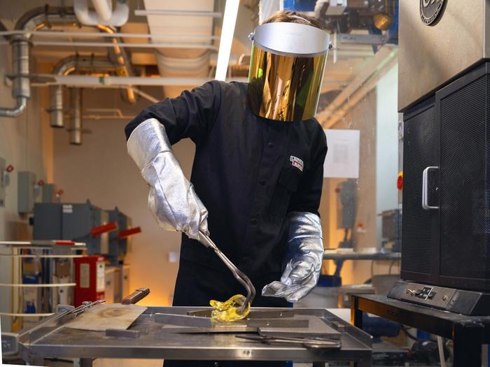 Nicholas Clark, a postdoctoral fellow at Penn State and one of the inventors of LionGlass, molds a piece of glass after removing it from a forge in the team's research lab.