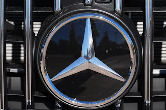 Mercedes-Benz chrome logo on vehicle grille with three-pointed star emblem