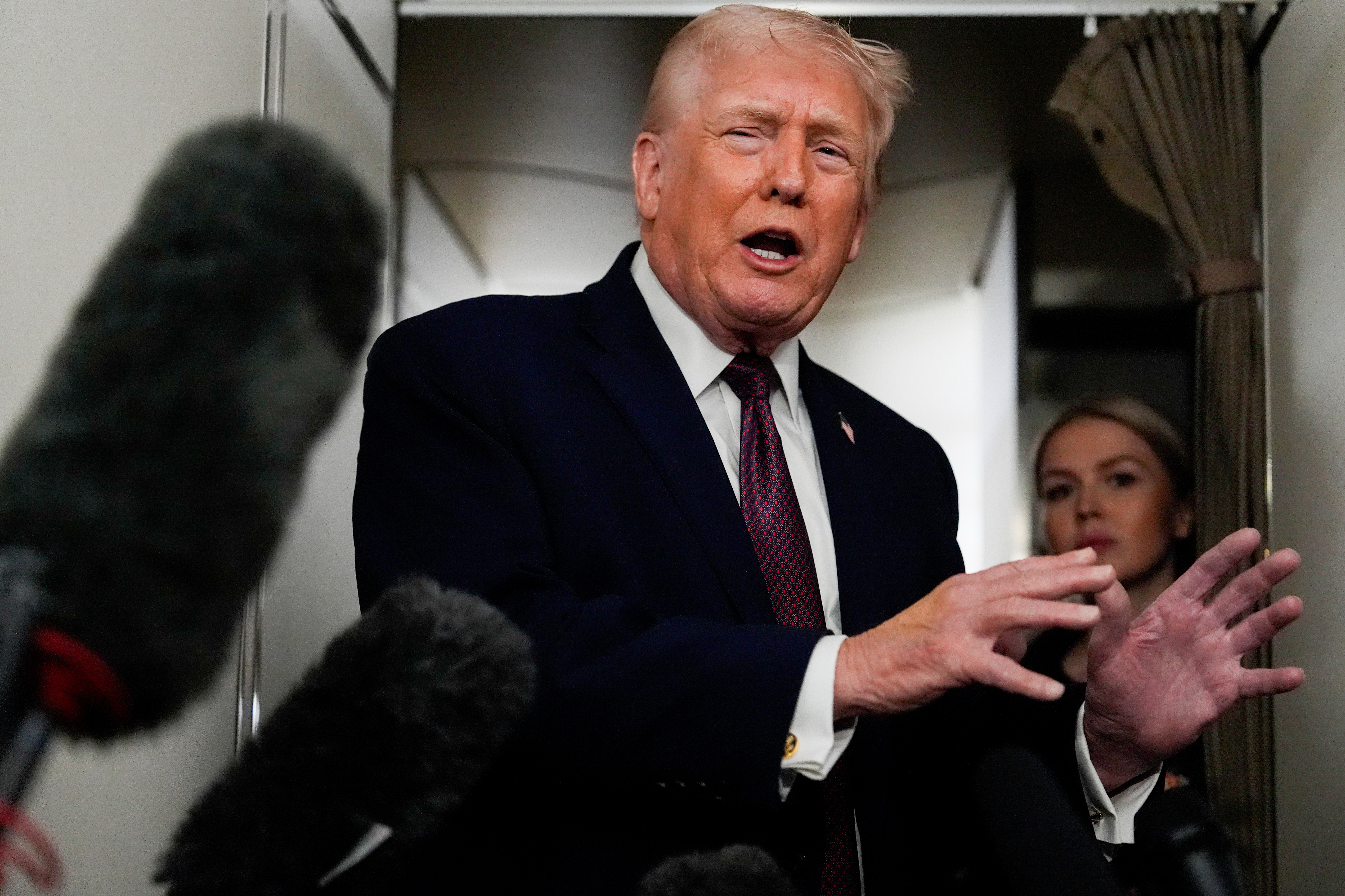 President Donald Trump speaks to reporters while in flight on Air Force One to Joint Base Andrews, Md., Sunday, Jan. 11, 2026.