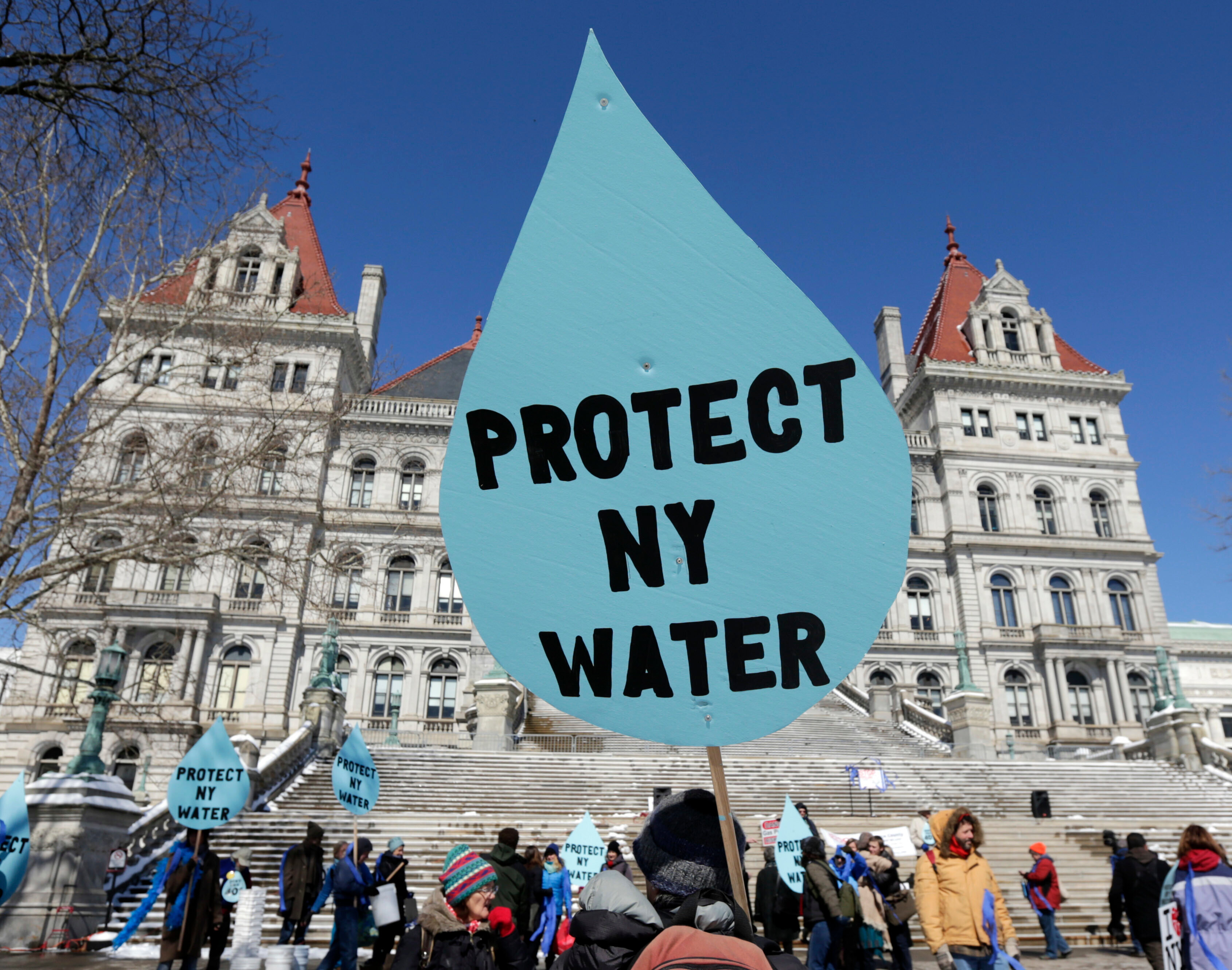 A man carries a sign before a rally opposing the Constitution Pipeline outside the state Capitol in Albany, N.Y., April 5, 2016.