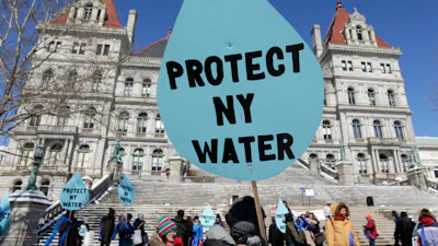 A man carries a sign before a rally opposing the Constitution Pipeline outside the state Capitol in Albany, N.Y., April 5, 2016.