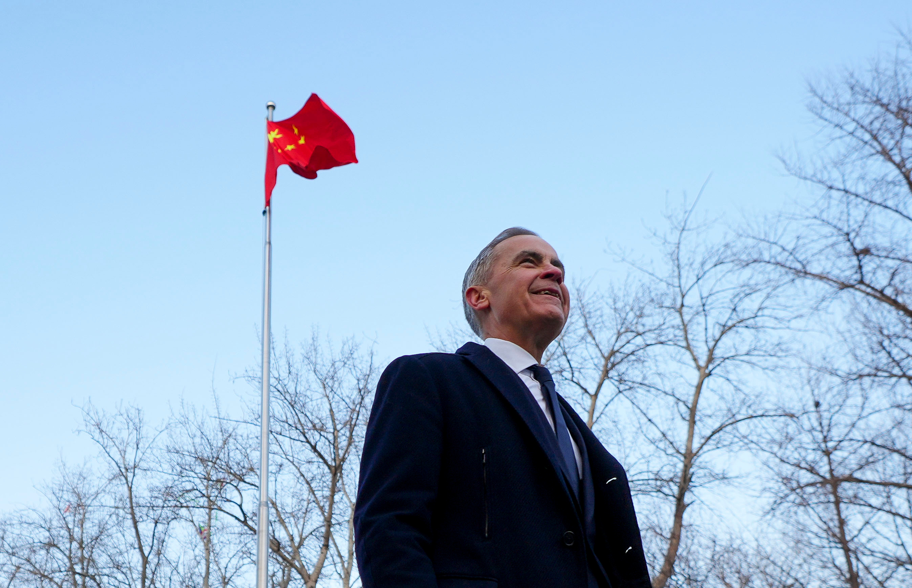 Canadian Prime Minister Mark Carney walks past a Chinese flag after a press conference in Ritan Park, Beijing, Jan. 16, 2026.