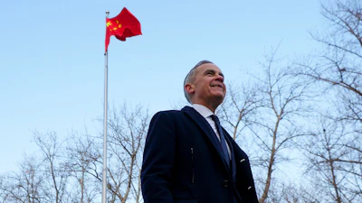 Canadian Prime Minister Mark Carney walks past a Chinese flag after a press conference in Ritan Park, Beijing, Jan. 16, 2026.