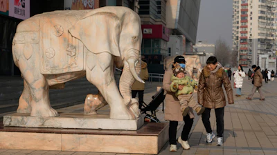 A woman lifts up a child in Beijing, Jan. 15, 2026.