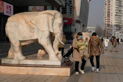 A woman lifts up a child in Beijing, Jan. 15, 2026.