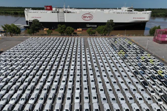 Aerial view of hundreds of white BYD electric vehicles parked at manufacturing facility