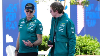 Aston Martin team principal Adrian Newey, left, talks with a team member as he arrives at the track ahead of the Australian Formula One Grand Prix at Albert Park, in Melbourne, Australia, Thursday, March 5, 2026.