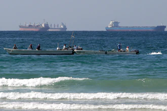 Fishermen work in front of oil tankers south of the Strait of Hormuz Jan. 19, 2012, offshore the town of Ras Al Khaimah in United Arab Emirates.
