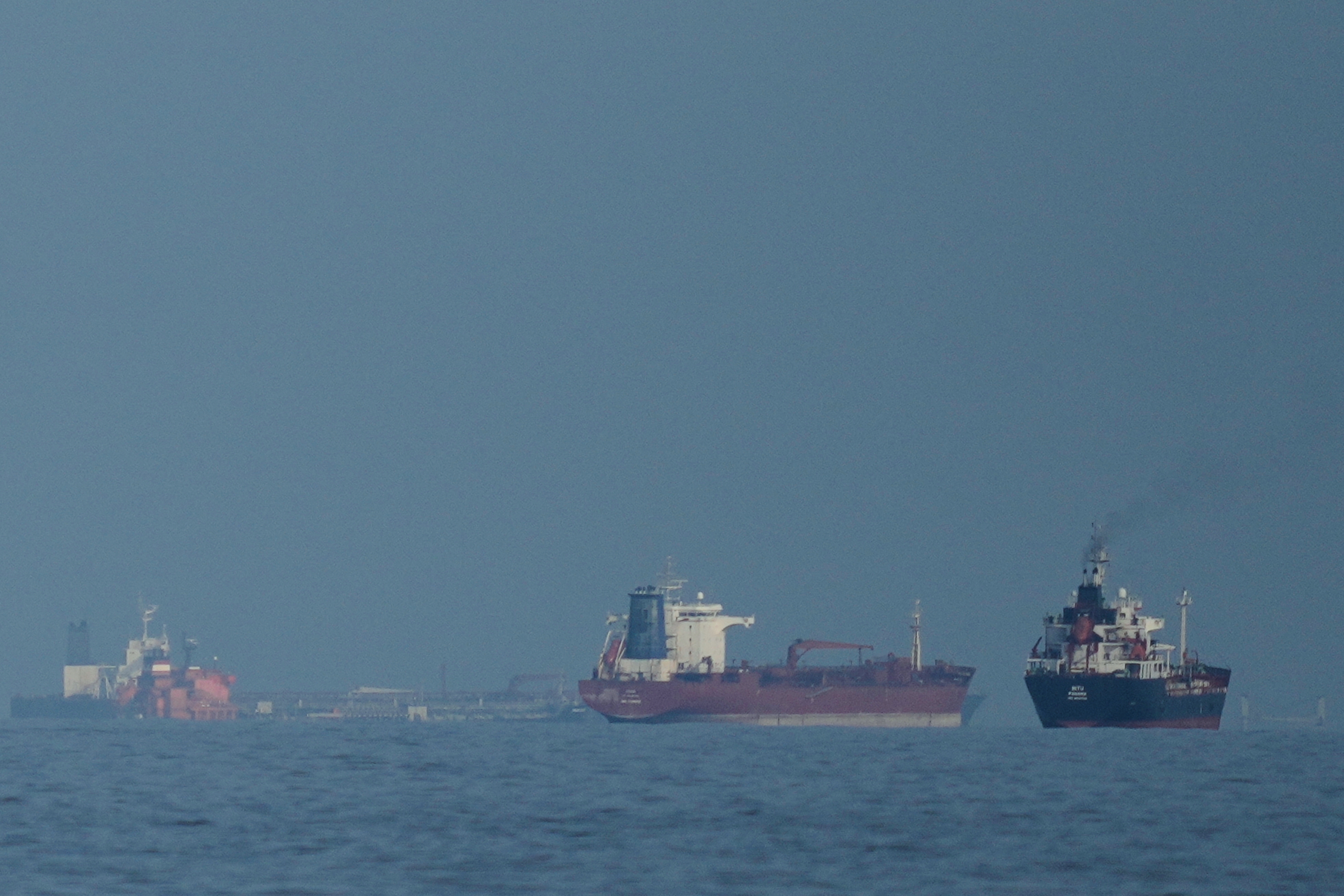 Oil tankers and cargo ships line up in the Strait of Hormuz as seen from Khor Fakkan, United Arab Emirates, March 11, 2026.