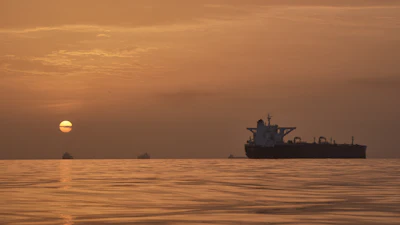 The sun rises behind tankers anchored in the Strait of Hormuz off the coast of Qeshm Island, Iran, April 18, 2026.
