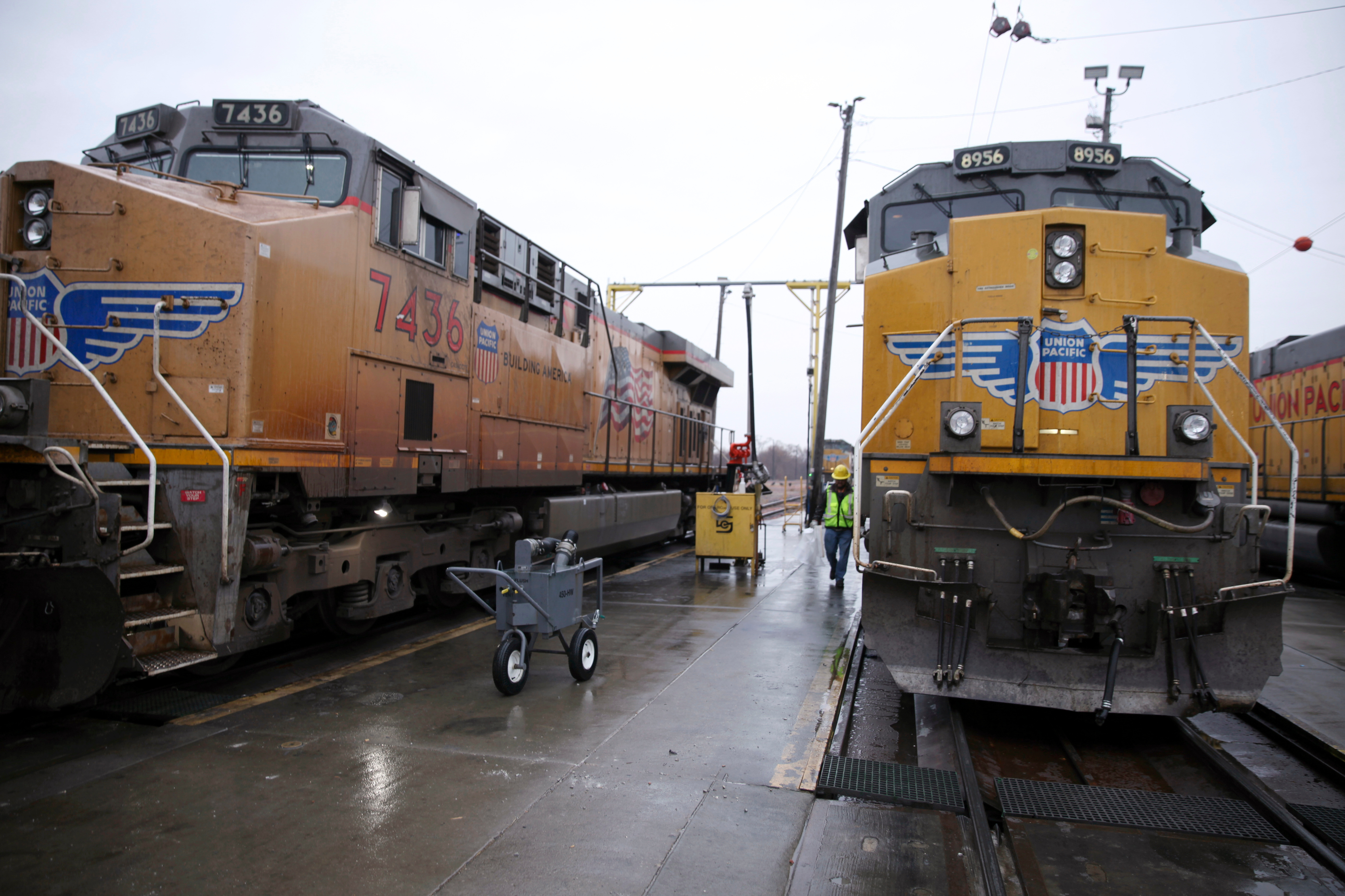 A Union Pacific worker walks between two locomotives in a railyard in Council Bluffs, Iowa, Dec. 15, 2023.