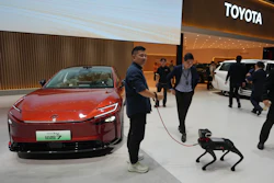 A visitor and his robotic dog stand near to the Toyota BZ7 EV model showcased at the Auto China 2026, in Beijing, Friday, April 24, 2026.