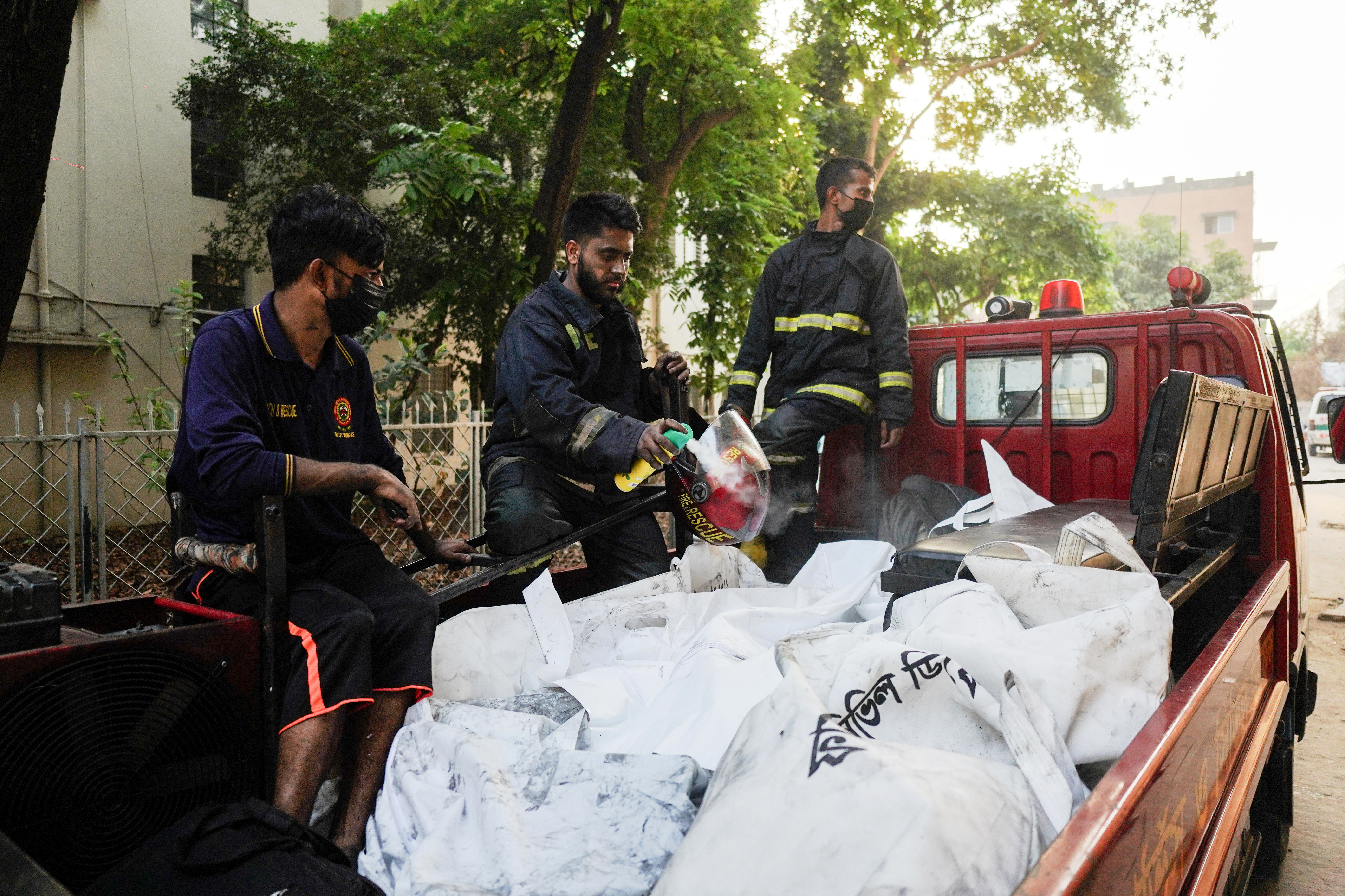 Firefighters transport the bodies of victims who lost their lives in a fire at a gas-lighter manufacturing factory in Keraniganj on the outskirts of Dhaka, Bangladesh, Saturday, April 4, 2026.