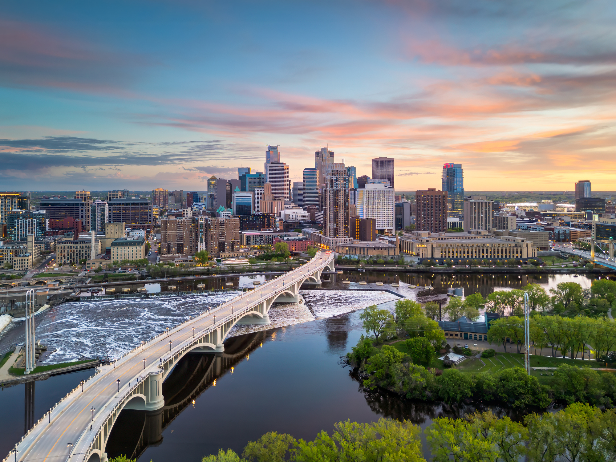 The Minneapolis, Minnesota, city skyline over the river at dusk.